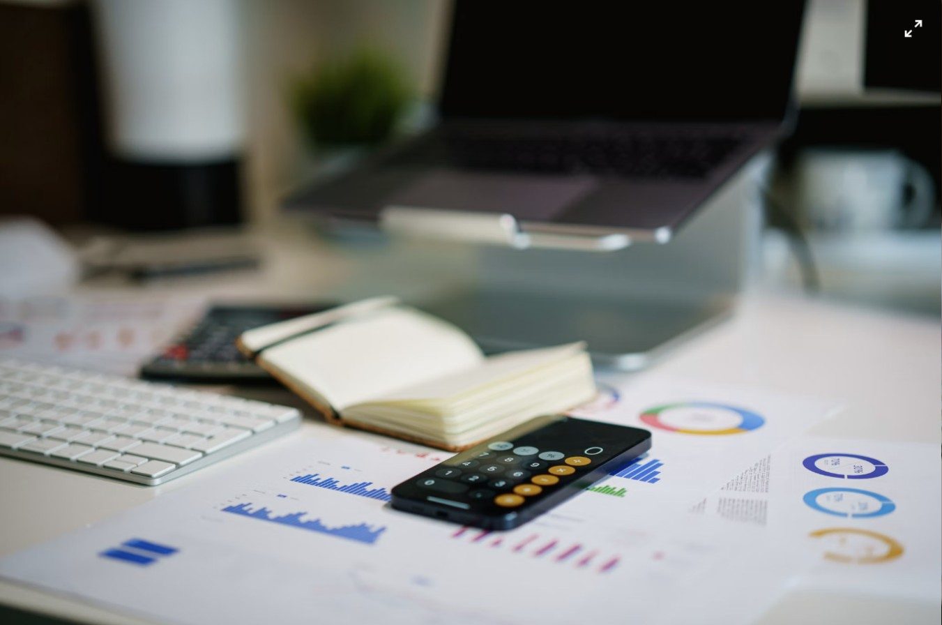 Escritorio de despacho de asesoría con calculadora y gráficos financieros